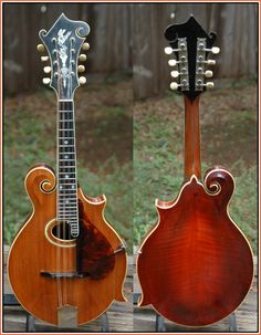 two guitars sitting side by side on top of a wooden table