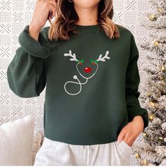 Get into the festive spirit with our "Nurse Sweatshirt." This Christmas-themed sweater features playful reindeer antlers on a stethoscope, making it a delightful choice for RNs, ER professionals, and nursing school students. Embrace the holiday season in comfort and style, and let this cozy crewneck sweatshirt become a fun and heartwarming addition to your wardrobe. Whether you're working through the holiday season or celebrating with your healthcare family, this sweatshirt is perfect for spread Christmas Sweaters Diy, Christmas Shirt Ideas, Brand Tshirt, Heart Anatomy, Reindeer Antlers, Cricut Christmas, Heart Tee