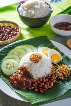 a plate with rice, beans, cucumbers and other food items on it