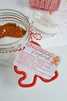 a jar filled with gingerbread flavored sugar next to a red and white striped twine