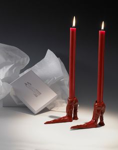 two red candles are next to an envelope