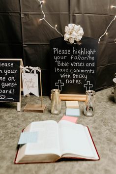 an open book sitting on top of a table next to two small vases filled with flowers