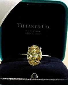 a fancy yellow diamond ring in a velvet box