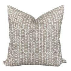 a gray and white pillow with an arrow pattern on the front, sitting on a white background