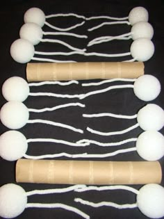 some white balls and rope on a black surface with one rolled up in the shape of a rectangle