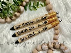 three pens with writing on them sitting next to some rocks