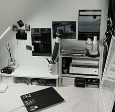 a desk with various electronics and pictures on it