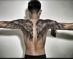 the back of a man's body with large wings on his upper and lower arm