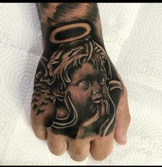 a man's hand with a tattoo on it and an angel above his head