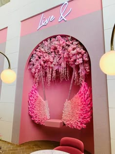 a pink and white room with flowers on the wall next to a round dining table