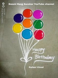 a happy birthday message written on the ground with balloons