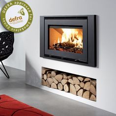 a fire place with logs in it and a wall mounted heater on the side