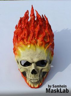 a skull mask with red and yellow flames on it's face is shown in front of a white background