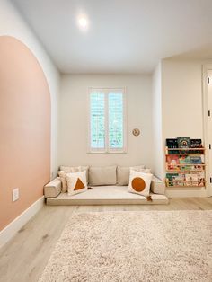 a living room filled with furniture and a book shelf next to a window on the wall