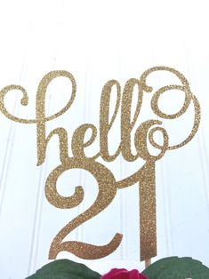 a cake topper that says hello 21st on it with some flowers in front of it