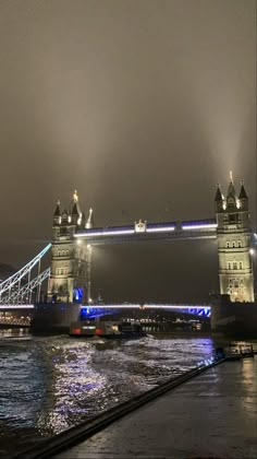 the tower bridge is lit up at night