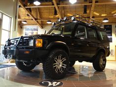 a black suv parked in a building with lights on it's roof and front bumper