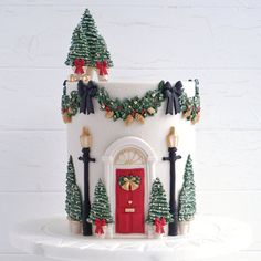 a white cake with a red door and christmas decorations