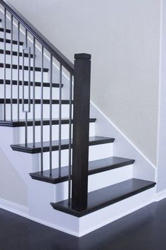 a black and white stair case next to a banister