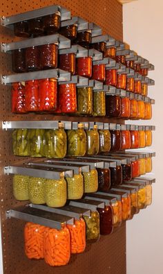 the shelves are filled with many different kinds of pickles and sauces on them