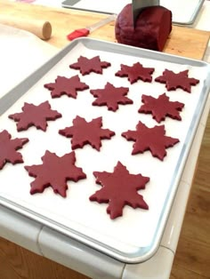 a pan filled with red cookies sitting on top of a counter