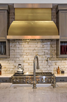 a kitchen with stainless steel appliances and white marble counter tops is pictured in this image