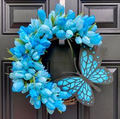 a wreath with blue flowers and a butterfly painted on the front door to give it a special touch