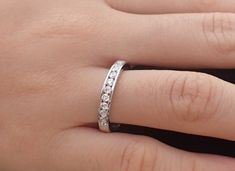 a woman's hand with a wedding ring on it and diamonds in the middle