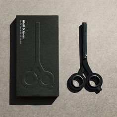 a pair of black scissors sitting next to a book