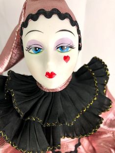 a close up of a mannequin's face wearing a black and pink dress