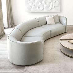 a white couch sitting next to a table on top of a carpeted living room floor