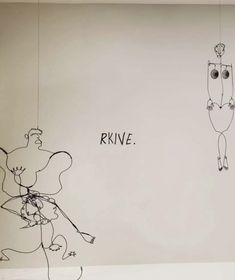 two drawings are hanging on the wall next to each other with words written above them