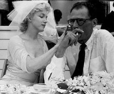 an old black and white photo of a bride and groom sitting at a dinner table