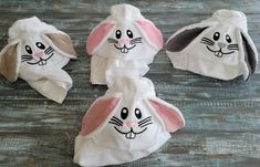 four towels with bunny ears on them sitting on a wooden floor next to each other