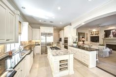 a large kitchen with white cabinets and granite counter tops