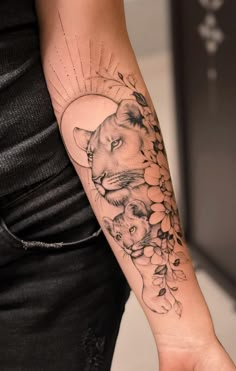 a woman's arm with a lion and flowers tattoo on it