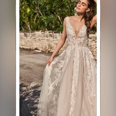 a woman in a wedding dress posing for the camera with her hand on her hip