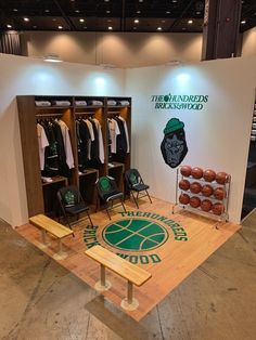 the basketball locker is set up with green and white shirts on hangers in front of it