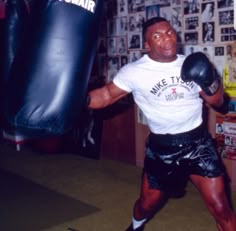 a man wearing black shorts and a white t - shirt is in a boxing ring