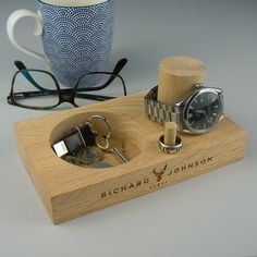 a wooden stand with two watches and some glasses on it next to a coffee cup