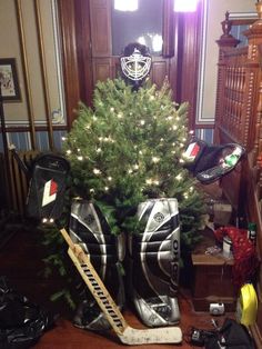 a christmas tree in a hockey goalie's boot with lights on it and other sports equipment