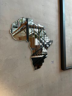 a mirror that is on the side of a wall next to a stair case and window