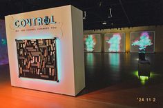 an exhibit room with artwork on the walls and lights in the backrounds