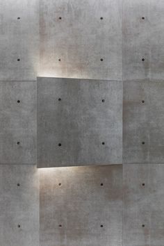 a concrete wall with holes in it and a light on the side that is lit up