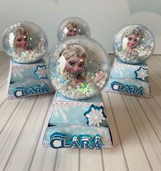 three snow globes with frozen princesses in them