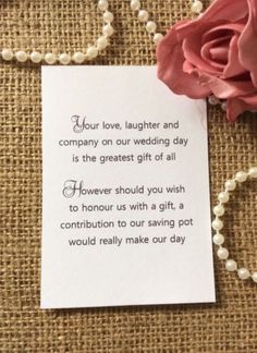 a card with a poem on it next to a flower and pearls hanging from a string