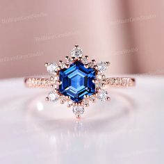 an engagement ring with blue and white stones on it, sitting on top of a table