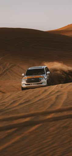 a white truck driving through the desert