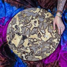 a person's hand on top of a round table covered in chocolate and marble