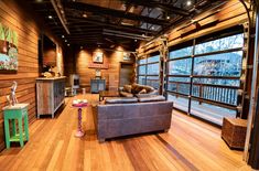 a living room filled with furniture and lots of wooden flooring on top of a hard wood floor